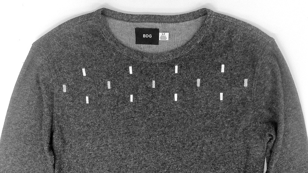 A Hint shirt is shown. The long sleeve t shirt is dark gray. The rectangles screenprinted across the front are white.