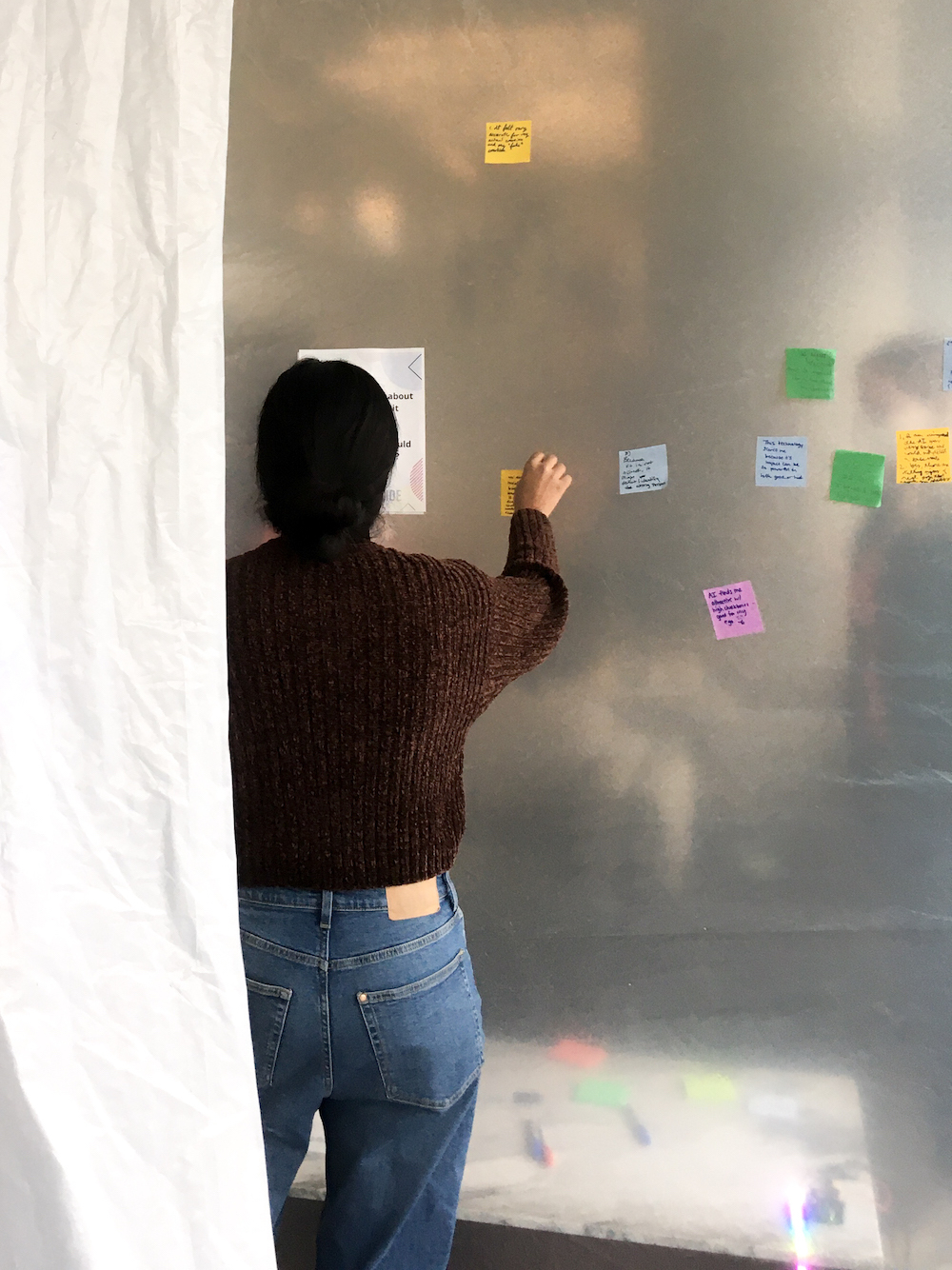 A person inside the inflatable adds a sticky note. Several other sticky notes are already posted to the inner surface of the inflatable.